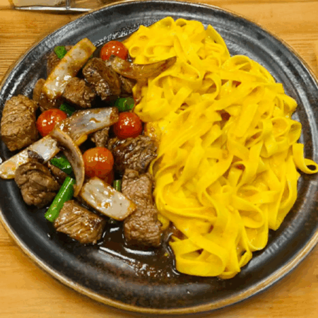 Tallarín a la Huancaína con Lomo Saltado – Un dúo irresistible de la cocina peruana